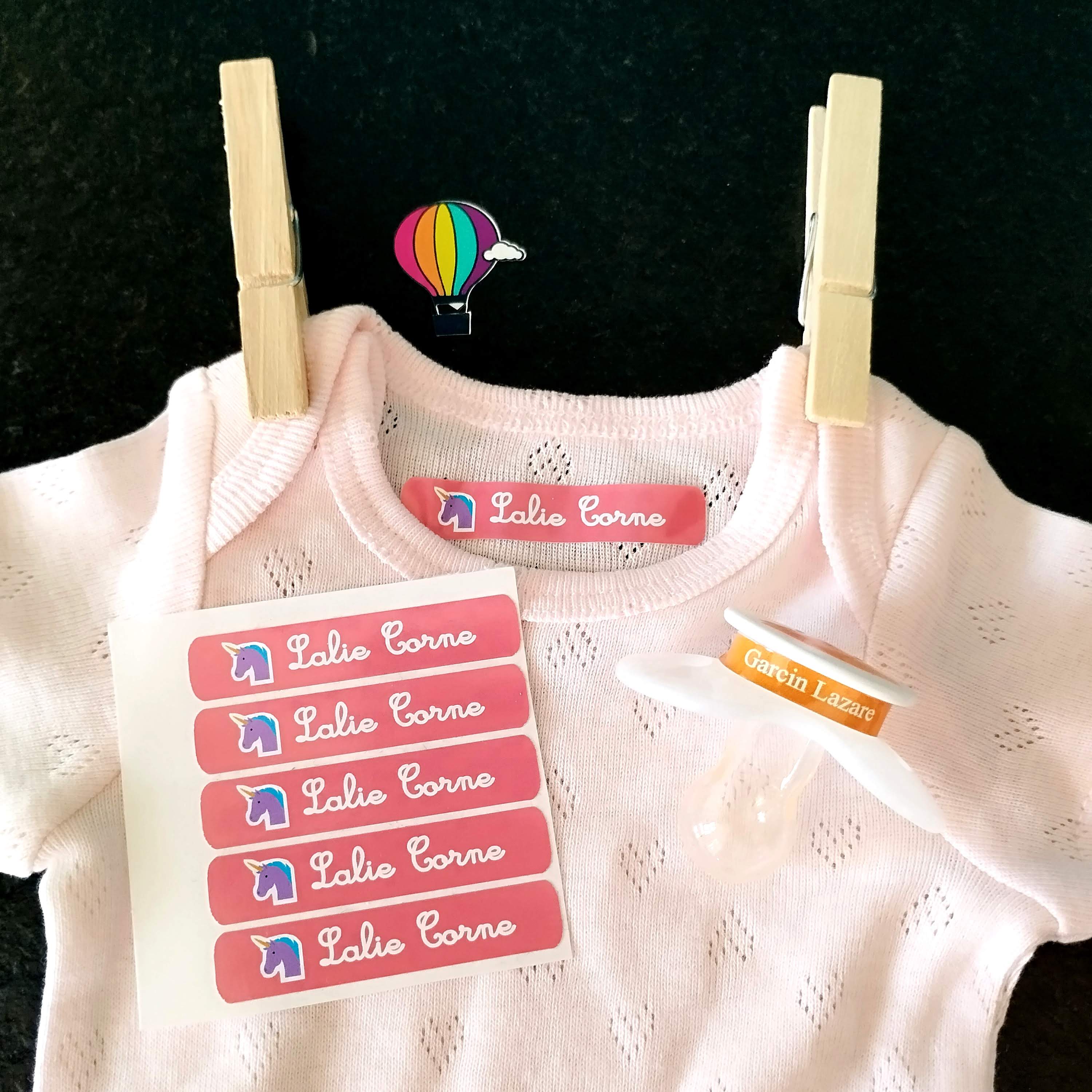 une étiquette thermocollante Marcabi fixée au fer à repasser sur un petit vêtement enfant/bébé 